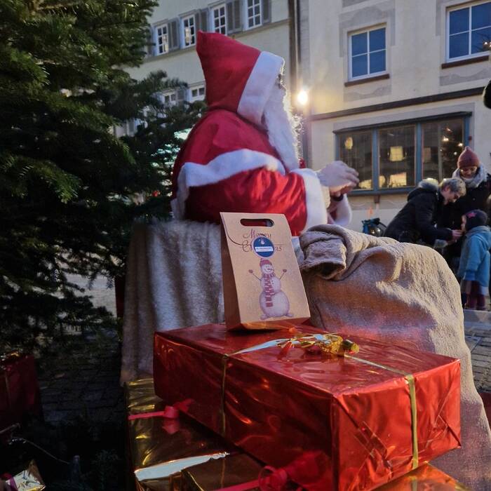 Weihnachtsmann sitzt unter dem Christbaum am Marktplatz