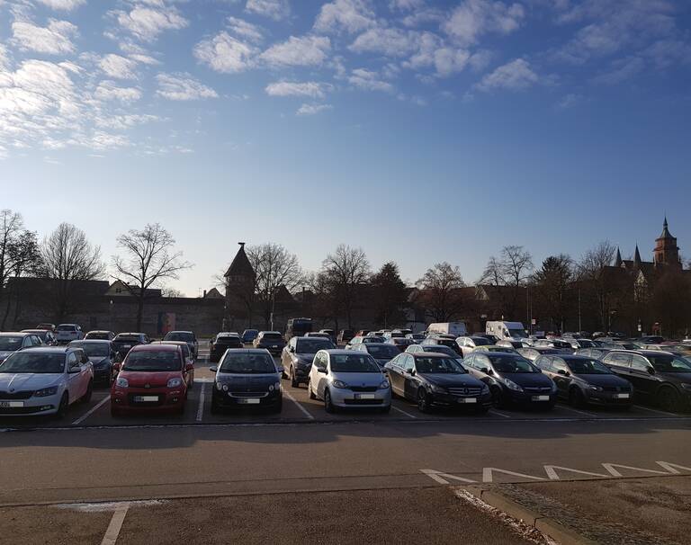 Viele Autos stehen auf einem Parkplatz.