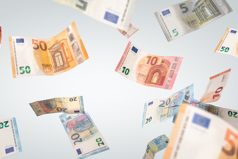 Mehrere Euro-Geldscheine fliegen umher.